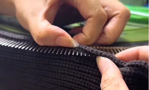 Precision hand linking and looping process on sweater panel seam edge loops
