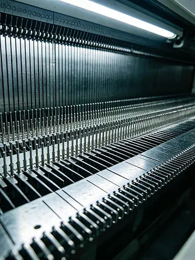 Precision Shima Seiki 18G knitting machine needle bed detail for fine gauge sweater production
