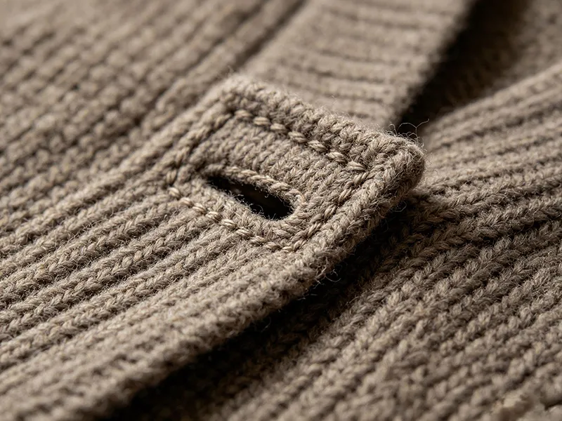 Macro view of bar-tack reinforced buttonhole on heavy knit