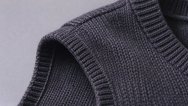 Inside shoulder seam of a women's heavy knit vest showing Mobilon tape reinforcement to prevent stretch deformation